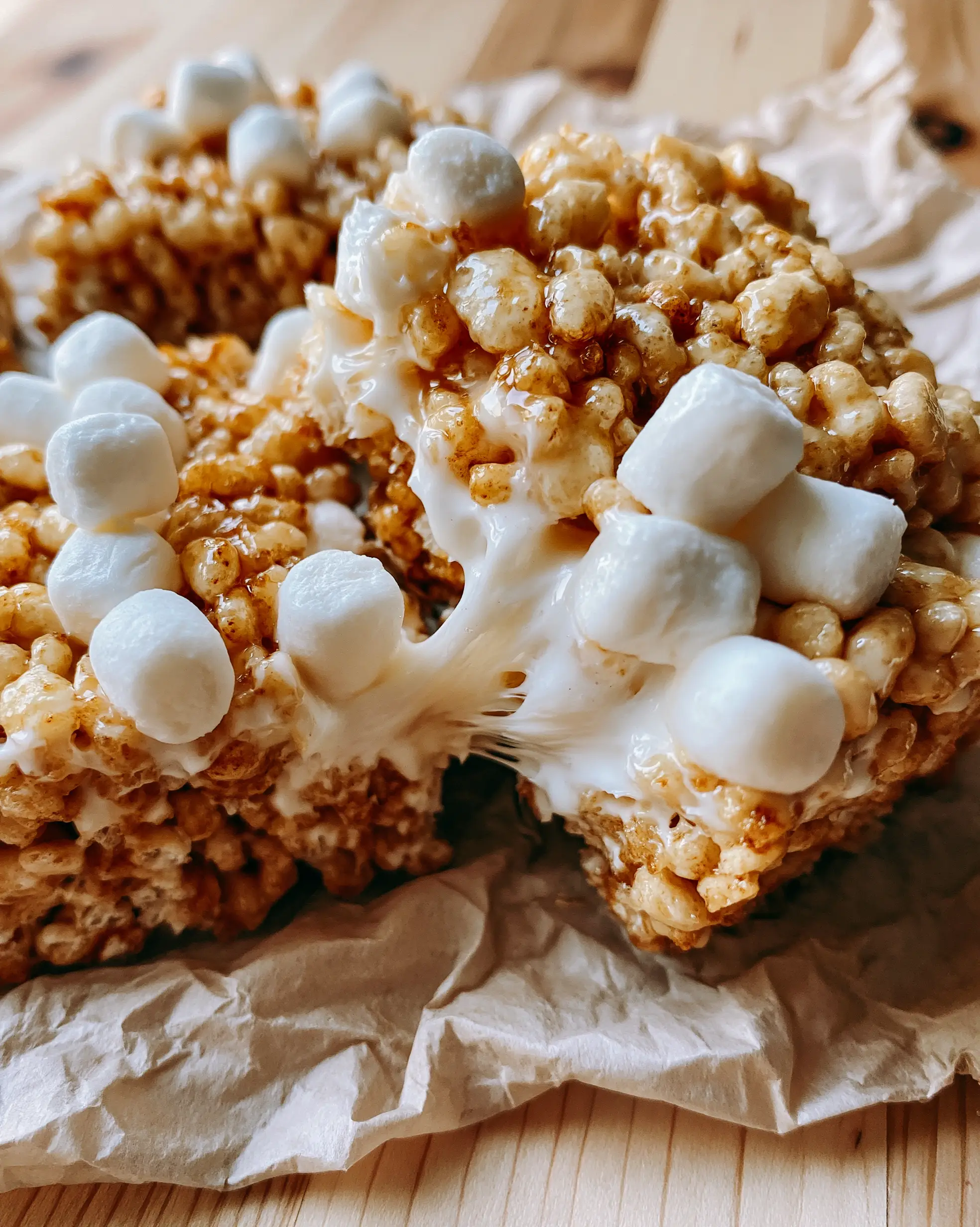 Extreme close-up of thick brown butter treats being pulled apart with gooey marshmallow webbing. (rice krispie treats recipe)