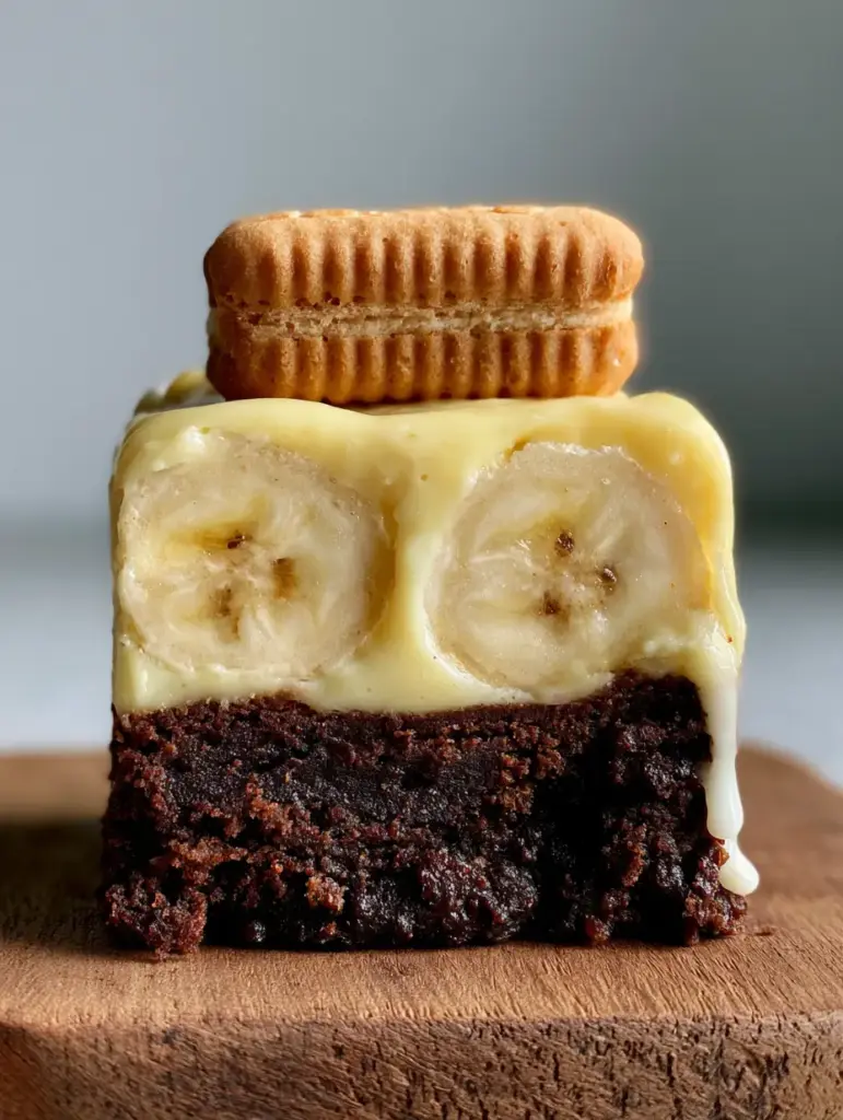 Macro eye-level photo of Banana Pudding Brownies showing the dense dark chocolate brownie and velvety pudding layer.